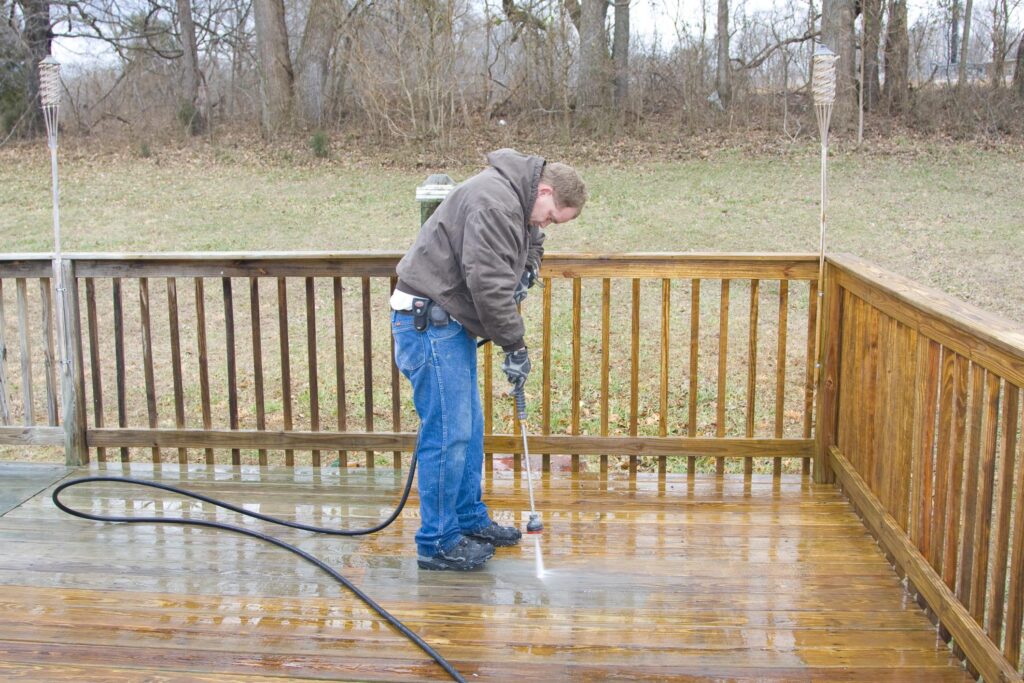 man power washing the wood deck floor